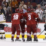  Boston Bruins' Johnny Boychuk (55) and Andrej Meszaros (41), of the Czech Republic, skate away as Phoenix Coyotes' Shane Doan (19) celebrates his goal with teammates Keith Yandle (3), Mike Ribeiro (63) and Brandon McMillan (38) during the first period of an NHL hockey game on Saturday, March 22, 2014, in Glendale, Ariz. (AP Photo/Ross D. Franklin)