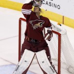 Arizona Coyotes' Mike Smith puts his mask back on during the second period of an NHL hockey game against the St. Louis Blues on Saturday, Oct. 18, 2014, in Glendale, Ariz. (AP Photo/Ross D. Franklin)