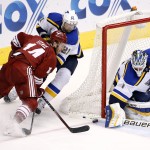 St. Louis Blues' Brian Elliott (1) makes a save on a shot by Arizona Coyotes' Joe Vitale, left, as Blues' Patrik Berglund (21), of Sweden, defends during the second period of an NHL hockey game Tuesday, Jan. 6, 2015, in Glendale, Ariz. (AP Photo/Ross D. Franklin)