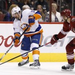 New York Islanders' Cal Clutterbuck (15) puts a shot on goal as Arizona Coyotes' Oliver Ekman-Larsson (23), of Sweden, defends during the first period of an NHL hockey game Saturday, Nov. 8, 2014, in Glendale, Ariz. (AP Photo/Ross D. Franklin)