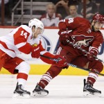 Arizona Coyotes' Lucas Lessio (38) battles for the puck with Detroit Red Wings' Gustav Nyquist (14), of Sweden, during the first period of an NHL hockey game Saturday, Feb. 7, 2015, in Glendale, Ariz. (AP Photo/Ross D. Franklin)