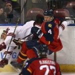 Florida Panthers' Dylan Olsen (4) slams Arizona Coyotes' Rob Klinkhammer (36) into the wall as they fight for the puck during the second period of an NHL hockey game in Sunrise, Fla., Thursday, Oct. 30, 2014. (AP Photo/J Pat Carter)
