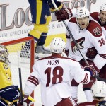 Arizona Coyotes left wing Rob Klinkhammer (36) celebrates with David Moss (18) and Kyle Chipchura (24) after scoring against Nashville Predators goalie Pekka Rinne, of Finland, left, in the first period of an NHL hockey game Tuesday, Oct. 21, 2014, in Nashville, Tenn. (AP Photo/Mark Humphrey)