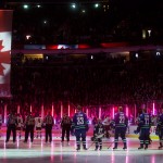 Players stand for the singing of the national anthems before an NHL hockey game between the Vancouver Canucks and the Arizona Coyotes in Vancouver, British Columbia, Monday, Dec. 22, 2014. (AP Photo/The Canadian Press, Darryl Dyck)