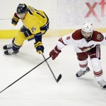 Arizona Coyotes defenseman David Schlemko (6) and Nashville Predators center Craig Smith (15) chase down the puck in the second period of an NHL hockey game Tuesday, Oct. 21, 2014, in Nashville, Tenn. (AP Photo/Mark Humphrey)