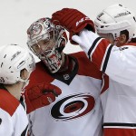 Carolina Hurricanes' Cam Ward, middle, smiles as he is congratulated by teammates Jeff Skinner (53) and Jay McClement (18) after an NHL hockey game against the Arizona Coyotes on Thursday, Feb. 5, 2015, in Glendale, Ariz. The Hurricanes defeated the Coyotes 2-1. (AP Photo/Ross D. Franklin)