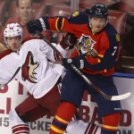 Arizona Coyotes' Mikkel Boedler (89) and Florida Panthers' Dmitry Kulikov (7) battle for the puck during the first period of an NHL hockey game in Sunrise, Fla., Thursday, Oct. 30, 2014. (AP Photo/J Pat Carter)

