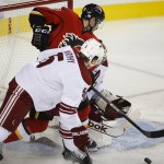 Arizona Coyotes' Connor Murphy, front, checks Calgary Flames' Curtis Glencross into goalie Mike Smith during the first period of an NHL hockey game Thursday, Nov. 13, 2014, in Calgary, Alberta. (AP Photo/The Canadian Press, Jeff McIntosh)