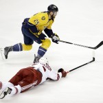 Arizona Coyotes defenseman Oliver Ekman-Larsson, bottom, of Sweden, dives for the puck as Nashville Predators left wing Viktor Stalberg (25), of Sweden, moves it down the ice in the first period of an NHL hockey game Tuesday, Oct. 21, 2014, in Nashville, Tenn. (AP Photo/Mark Humphrey)