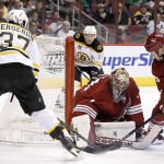  Boston Bruins' Patrice Bergeron (37) scores a goal against Phoenix Coyotes' Mike Smith, third from the left, as Coyotes' Derek Morris (53) defends and Coyotes' Keith Yandle, back right, and Bruins' Brad Marchand (63) look on during the first period of an NHL hockey game on Saturday, March 22, 2014, in Glendale, Ariz. (AP Photo/Ross D. Franklin)