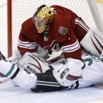  Dallas Stars' Ryan Garbutt, front, slides into Phoenix Coyotes' Thomas Greiss, of Germany, after falling in front of the goalie during the first period of an NHL hockey game on Sunday, April 13, 2014, in Glendale, Ariz. (AP Photo/Ross D. Franklin)