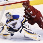 St. Louis Blues' Brian Elliott (1) pokes the puck away as Arizona Coyotes' Shane Doan (19) moves in to try to get a stick on the puck during the second period of an NHL hockey game Tuesday, Jan. 6, 2015, in Glendale, Ariz. (AP Photo/Ross D. Franklin)