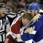 Linesman Pierre Racicot, left, tries to break up a fight by Tampa Bay Lightning center Cedric Paquette, right, and Arizona Coyotes defenseman Connor Murphy during the second period of an NHL hockey game Tuesday, Oct. 28, 2014, in Tampa, Fla. (AP Photo/Chris O'Meara)