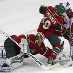 Minnesota Wild goalie Darcy Kuemper, left, reaches for the puck as Jared Spurgeon keeps Arizona Coyotes' Sam Gagner away during the third of an NHL hockey game, Thursday, Oct. 23, 2014, in St. Paul, Minn. The Wild won 2-0. (AP Photo/Jim Mone)
