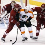 Philadelphia Flyers' R.J. Umberger (18) gets shoved by Arizona Coyotes' Connor Murphy (5) and Brandon Gormley (33) as he loses the puck in front of Coyotes' Devan Dubnyk (40) during the second period of an NHL hockey game Monday, Dec. 29, 2014, in Glendale, Ariz. (AP Photo/Ross D. Franklin)
