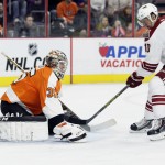 Philadelphia Flyers goalie Steve Mason (35), left, who replaced Ray Emery early in the first period, covers up the puck from an advancing Arizona Coyotes' Martin Erat (10) right, in an NHL hockey game, Tuesday, Jan. 27, 2015, in Philadelphia. (AP Photo/Tom Mihalek)