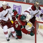 Minnesota Wild's Justin Fontaine, center, falls as he chases the puck between Arizona Coyotes' Connor Murphy, left, and goalie Mike Smith during the first period of an NHL hockey game, Thursday, Oct. 23, 2014, in St. Paul, Minn. (AP Photo/Jim Mone)
