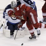 Winnipeg Jets' Ondrej Pavelec, left, of the Czech Republic, makes a save on a shot by Arizona Coyotes' B.J. Crombeen (44) during the third period of an NHL hockey game Thursday, Oct. 9, 2014, in Glendale, Ariz. The Jets defeated the Coyotes 6-2. (AP Photo/Ross D. Franklin)