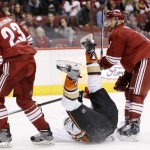 Anaheim Ducks' Ryan Kesler, middle, goes sliding along the ice but not before scoring a short-handed goal getting the puck past Arizona Coyotes' Oliver Ekman-Larsson (23), of Sweden, and Sam Gagner, right, during the first period of an NHL hockey game Tuesday, March 3, 2015, in Glendale, Ariz. (AP Photo/Ross D. Franklin)