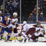 Arizona Coyotes defenseman Keith Yandle (3), center Sam Gagner (9), center Tobias Rieder (8) and New York Islanders left wing Nikolay Kulemin (86) watch a puck shot by Islanders center Kael Mouillierat soar past Arizona Coyotes goalie Mike Smith (41) to score in the third period of an NHL hockey game Tuesday, Feb. 24, 2015, in Uniondale, N.Y. The goal was Mouillierat's first NHL goal. The Islanders won 5-1. (AP Photo/Kathy Kmonicek)