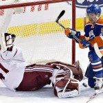 Arizona Coyotes goalie Mike Smith (41) makes the save as Edmonton Oilers' David Perron (57) battles for the puck in front of the goal during the second period of an NHL hockey game in Edmonton, Alberta, on Monday, Dec. 1, 2014. (AP Photo/The Canadian Press, Jason Franson)