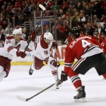 Arizona Coyotes right wing Shane Doan (19) takes a shot between Chicago Blackhawks' Niklas Hjalmarsson (4) and Brad Richards (91) as Antoine Vermette (50) breaks to the net during the first period of an NHL hockey game Tuesday, Jan. 20, 2015, in Chicago. (AP Photo/Charles Rex Arbogast)
