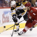  Boston Bruins' Johnny Boychuk (55) and Phoenix Coyotes' Keith Yandle (3) battle for the puck during the first period of an NHL hockey game on Saturday, March 22, 2014, in Glendale, Ariz. (AP Photo/Ross D. Franklin)