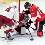 Ottawa Senators' Clarke MacArthur (16) fights for the puck with Arizona Coyotes' goaltender Mike Smith (41) and Zbynek Michalek (4) reacts during the first period of an NHL hockey game in Ottawa, Ontario, Saturday, Jan. 31, 2015. (AP Photo/The Canadian Press, Fred Chartrand)
