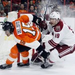 Philadelphia Flyers' Michale Del Zotto (15), left, and Arizona Coyotes' Shane Doan (19), right, pursue the puck near the Coyotes' goal in the overtime period of an NHL hockey game, Tuesday, Jan. 27, 2015, in Philadelphia. The Flyers won 4-3. (AP Photo/Tom Mihalek)