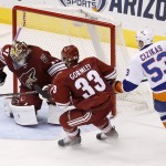 Arizona Coyotes' Mike Smith (41) makes a save on a shot by New York Islanders' Casey Cizikas (53) as Coyotes' Brandon Gormley (33) defends during the second period of an NHL hockey game Saturday, Nov. 8, 2014, in Glendale, Ariz. (AP Photo/Ross D. Franklin)