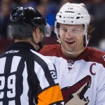 Arizona Coyotes captain Shane Doan laughs with referee Ian Walsh during the first period of an NHL hockey game in Vancouver, British Columbia, Monday, Dec. 22, 2014. (AP Photo/The Canadian Press, Darryl Dyck)