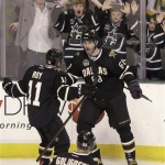 Fans cheers in the background as Dallas Stars right wing Jaromir Jagr (68) celebrates his goal with teammate Derek Roy during the first period of an NHL hockey game against the Phoenix Coyotes on Saturday, Jan. 19, 2013, in Dallas. (AP Photo/LM Otero)
