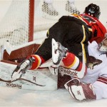  Phoenix Coyotes goalie Mike Smith, right, looks on as Calgary Flames' Sean Monahan crashes over him after scoring during first period NHL hockey action in Calgary, Canada, Wednesday, Jan. 22, 2014. (AP Photo/The Canadian Press, Jeff McIntosh)