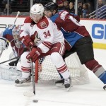 Phoenix Coyotes center Kyle Chipchura (24) backs toward the net as Colorado Avalanche defenseman Erik Johnson (6) defends with Avalanche goalie Semyon Varlamov, of Russia, (1) during the first period of an NHL hockey game in Denver on Tuesday, Dec. 10, 2013. (AP Photo/Joe Mahoney)