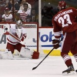 Detroit Red Wings' Jimmy Howard, left, makes a save on a slap shot by Phoenix Coyotes' Oliver Ekman-Larsson (23), of Sweden, in the first period during an NHL hockey game on Thursday, April 4, 2013, in Glendale, Ariz. (AP Photo/Ross D. Franklin)