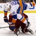 New York Islanders' John Tavares (91) leaps over Phoenix Coyotes' Oliver Ekman-Larsson, of Sweden, during the first period of an NHL hockey game Thursday, Dec. 12, 2013, in Glendale, Ariz. (AP Photo/Ross D. Franklin)