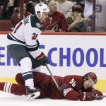 Minnesota Wild's Kyle Brodziak (21) sends Phoenix Coyotes' Antoine Vermette (50) to the ice during the third period in an NHL hockey game Thursday, Jan. 9, 2014, in Glendale, Ariz. The Wild defeated the Coyotes 4-1. (AP Photo/Ross D. Franklin)