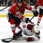 Chicago Blackhawks' Dave Bolland, left, takes Phoenix Coyotes' Rob Klinkhammer, right, to the ice during the first period of an NHL hockey game on Saturday, Apr. 20, 2013, in Chicago. (AP Photo/John Smierciak)