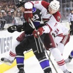 Los Angeles Kings right wing Dustin Brown (23) and Phoenix Coyotes center Martin Hanzal (11), of the Czech Republic, battle for the puck during the third period of an NHL hockey game, Monday, March 18, 2013, in Los Angeles. The Kings won 4-0. (AP Photo/Gus Ruelas)