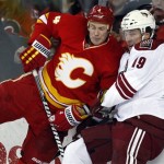 Phoenix Coyotes' Shane Doan, right, and Calgary Flames' Jay Bouwmeester crash into the boards during the second period of an NHL hockey game in Calgary, Alberta, Sunday, Feb. 24, 2013. (AP Photo/The Canadian Press, Jeff McIntosh)
