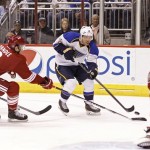 St Louis Blues' Derek Roy (12) skates the puck in on Phoenix Coyotes goaltender Mike Smith, right, as Keith Yandle (3) and Mikkel Boedker, of Denmark, left, defend during the first period of an NHL hockey game, Sunday, March. 2, 2014, in Glendale, Ariz. (AP Photo/Ralph Freso)