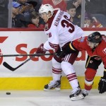 Phoenix Coyotes' Rob Klinkhammer, left, battles for the puck with Calgary Flames' TJ Brodie during second-period NHL hockey game action in Calgary, Alberta, Friday, April 12, 2013. (AP Photo/The Canadian Press, Larry MacDougal)