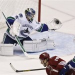 Vancouver Canucks' Cory Schneider, left, makes a glove save on a shot by Phoenix Coyotes' Shane Doan (19) as Canucks' Dan Hamhuis (2) defends during the second period in an NHL hockey game, Thursday, March 21, 2013, in Glendale, Ariz. (AP Photo/Ross D. Franklin)