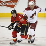  Phoenix Coyotes' David Moss, right, and Calgary Flames' Lee Stempniak chase the puck during first period NHL hockey action in Calgary, Canada, Wednesday, Jan. 22, 2014. (AP Photo/The Canadian Press, Jeff McIntosh)