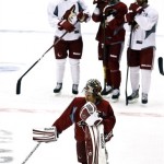 Phoenix Coyotes goalie Mike Smith, front, kneels as he and teammates wait for their shift during an NHL hockey practice, Tuesday, Jan. 15, 2013, in Glendale, Ariz. (AP Photo/Ross D. Franklin)