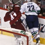 Vancouver Canucks' Alexander Edler (23), of Sweden, knocks Phoenix Coyotes' Mike Smith (41) to the ice, and gets called for a five-minue charging penalty, during the second period in an NHL hockey game, Thursday, March 21, 2013, in Glendale, Ariz. (AP Photo/Ross D. Franklin)