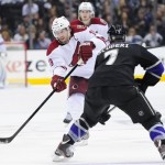 Phoenix Coyotes right wing Shane Doan (19) takes a shot on Los Angeles Kings defenseman Rob Scuderi (7) from center ice during the third period of an NHL hockey game, Monday, March 18, 2013, in Los Angeles. The Kings won 4-0. (AP Photo/Gus Ruelas)