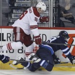  Winnipeg Jets' Tobias Enstrom (39) is dumped into the boards by Phoenix Coyotes' Rob Klinkhammer (36) during first-period NHL hockey game action in Winnipeg, Manitoba, Thursday, Feb. 27, 2014. (AP Phoyo/The Canadian Press, John Woods)