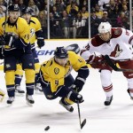 Nashville Predators defenseman Ryan Ellis (4) dives for the puck against Phoenix Coyotes left wing David Moss (18) in the first period of an NHL hockey game, Thursday, Feb. 14, 2013, in Nashville, Tenn. At left is Predators center Nick Spaling (13). (AP Photo/Mark Humphrey)