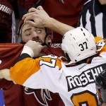 Philadelphia Flyers' Jay Rosehill (37) gives Phoenix Coyotes' Paul Bissonnette, left, a hand to the face as they fight during the second period of an NHL hockey game Saturday, Jan. 4, 2014, in Glendale, Ariz. (AP Photo/Ross D. Franklin)